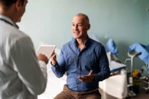 Doctor reviewing hormone labs with a male patient about gynecomastia from TRT