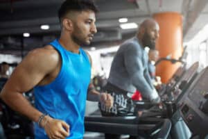 Man on a treadmill checking for the signs of high testosterone during training